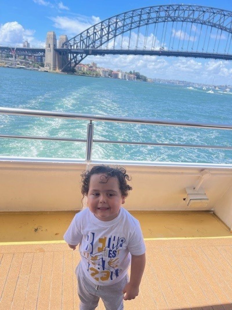 Raphael on a boat in Sydney Harbour. Sydney Harbour Bridge in background.